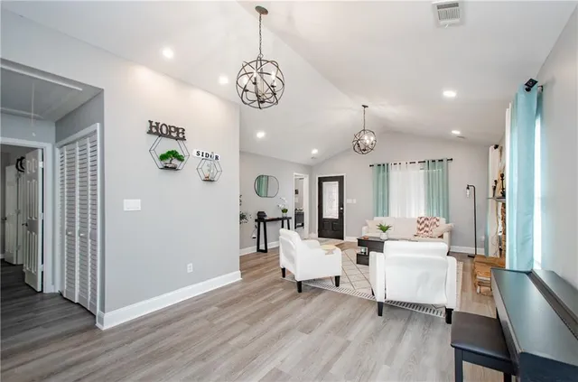 a living room with furniture and a chandelier