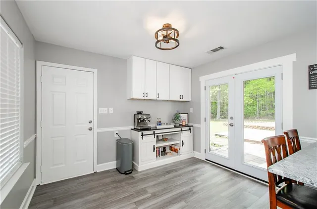 a kitchen with granite countertop a stove a sink and a refrigerator with wooden floors