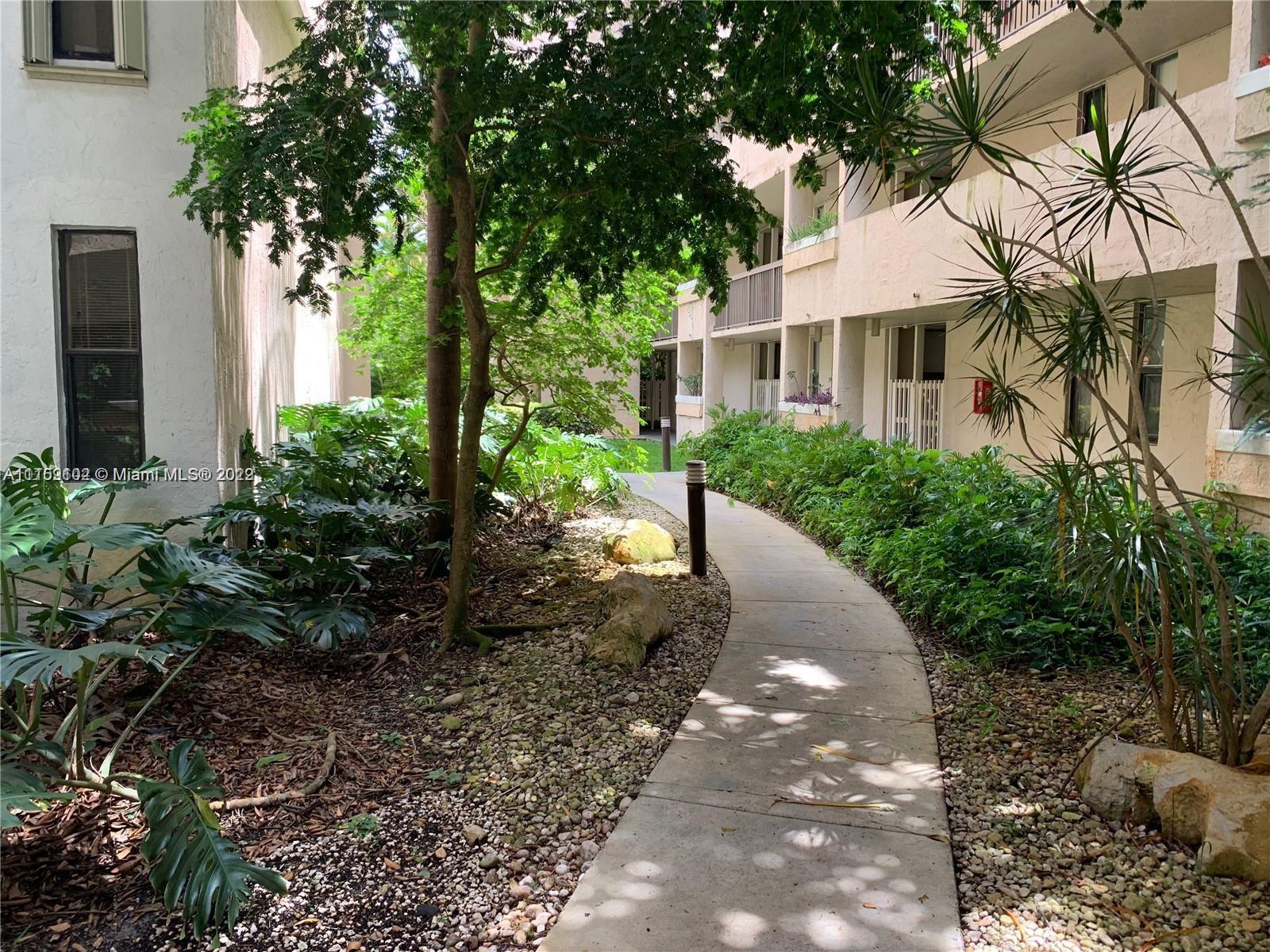 6800 Cypress Road, Unit 208 Plantation, FL 33317 - Photo 2 of 13 a front view of a house with a yard and potted plants
