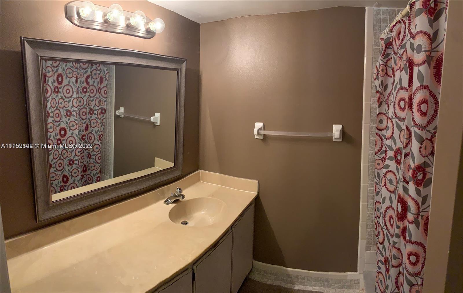 6800 Cypress Road, Unit 208 Plantation, FL 33317 - Photo 10 of 13 a bathroom with a sink and a mirror