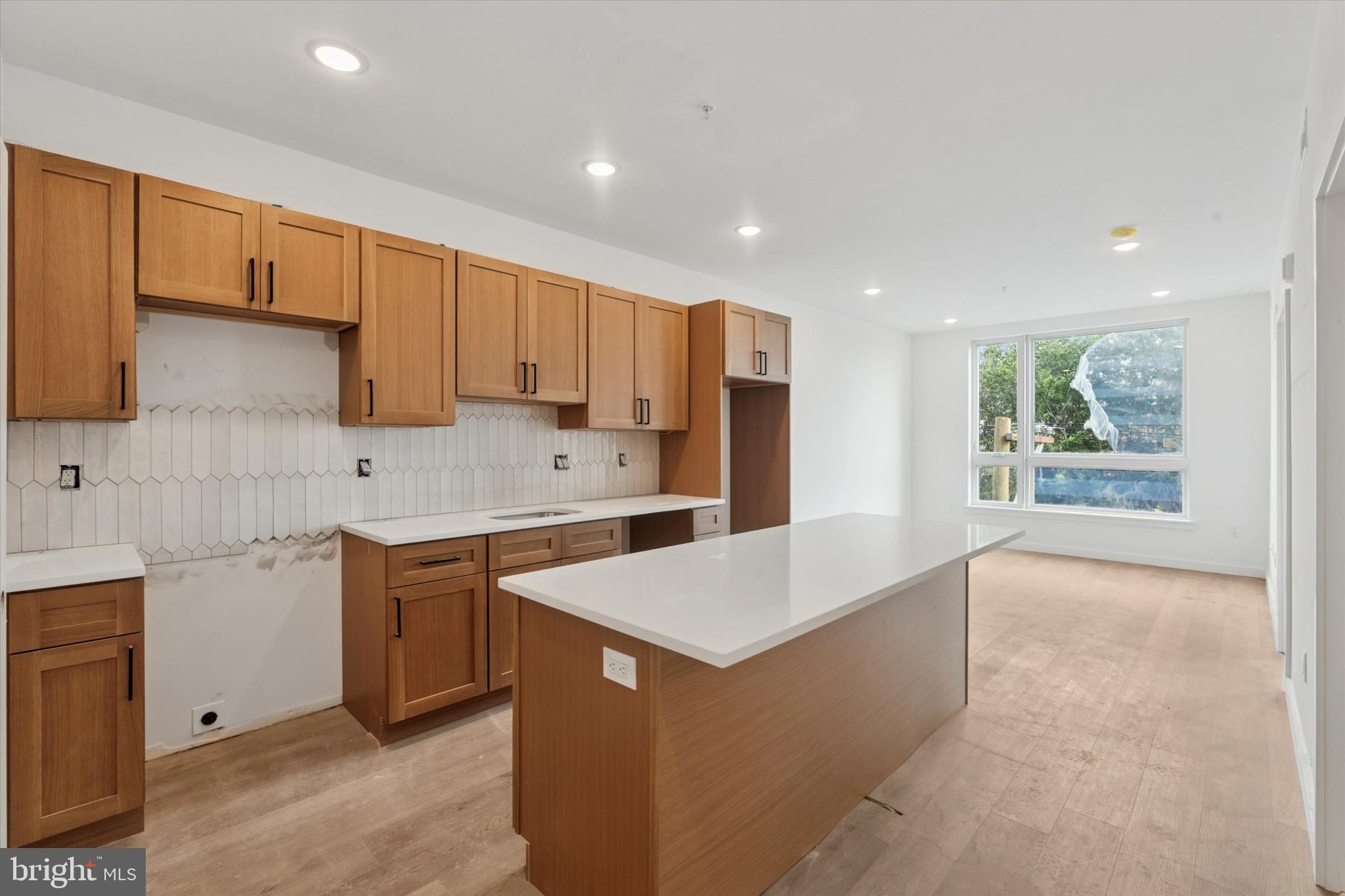 a large kitchen with stainless steel appliances a white stove top oven sink and cabinets