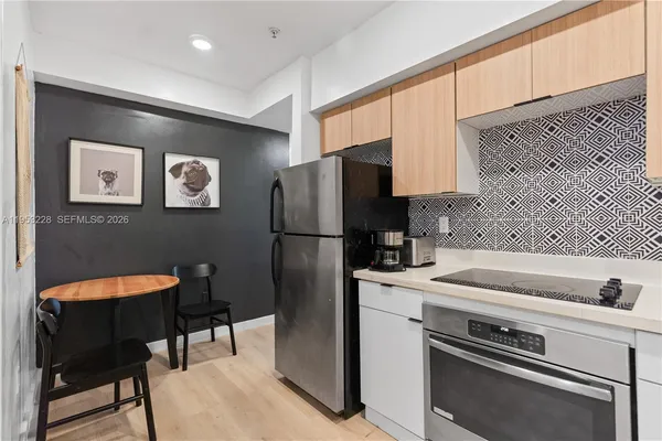 a kitchen with stainless steel appliances a refrigerator and a stove top oven
