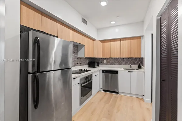 a kitchen with stainless steel appliances a refrigerator sink and cabinets
