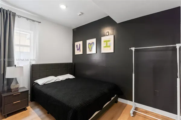 a bed sitting in a bedroom next to a window