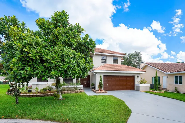 a front view of a house with a garden and yard