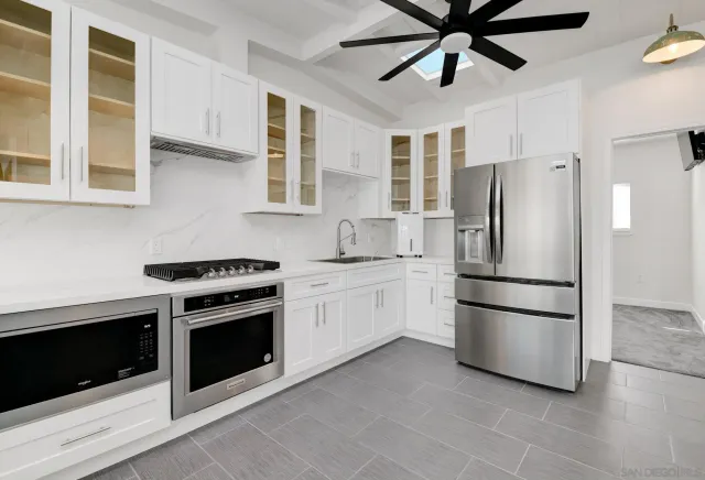 a kitchen with stainless steel appliances granite countertop a refrigerator a stove a sink and a refrigerator