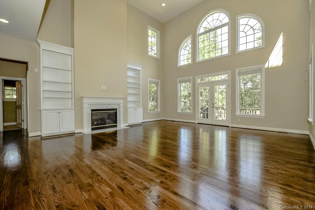 955 Cove Point Lane Tega Cay, SC 29708 - Photo 8 of 24 an empty room with wooden floor fireplace and windows