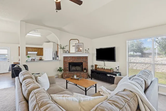 a living room with furniture a flat screen tv and a fireplace