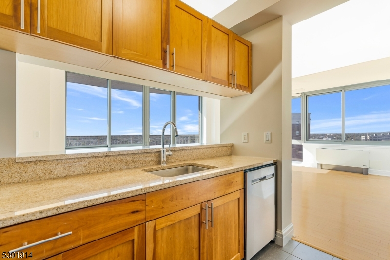 1 Spring Street, Unit 1704 New Brunswick, NJ 08901 - Photo 11 of 44 a kitchen with stainless steel appliances granite countertop a sink and a white cabinets