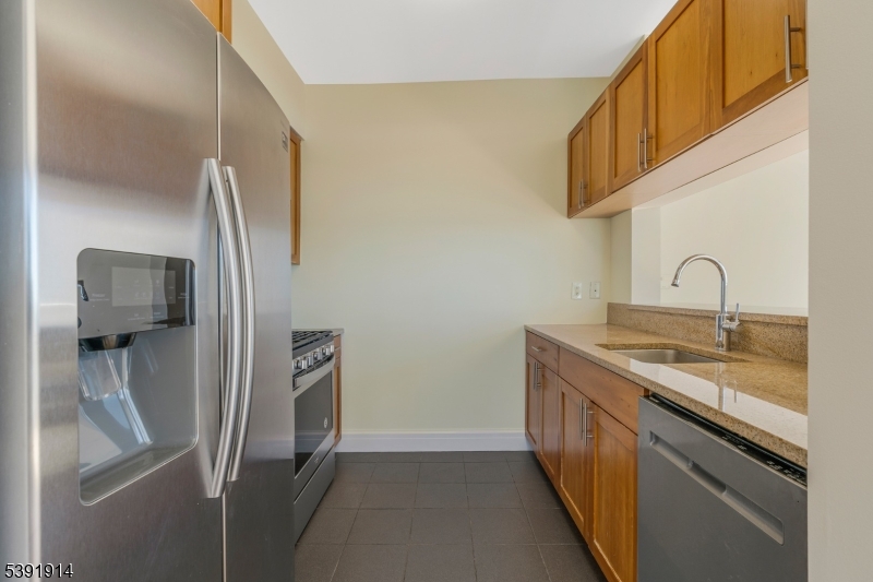 1 Spring Street, Unit 1704 New Brunswick, NJ 08901 - Photo 13 of 44 a kitchen with stainless steel appliances granite countertop a refrigerator and a sink