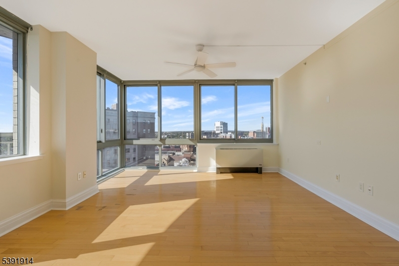 1 Spring Street, Unit 1704 New Brunswick, NJ 08901 - Photo 8 of 44 a living room with a large window wooden floor and furniture