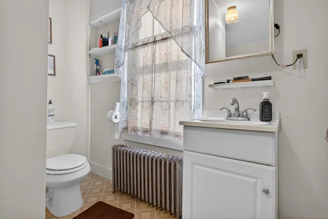 a bathroom with a sink toilet and window