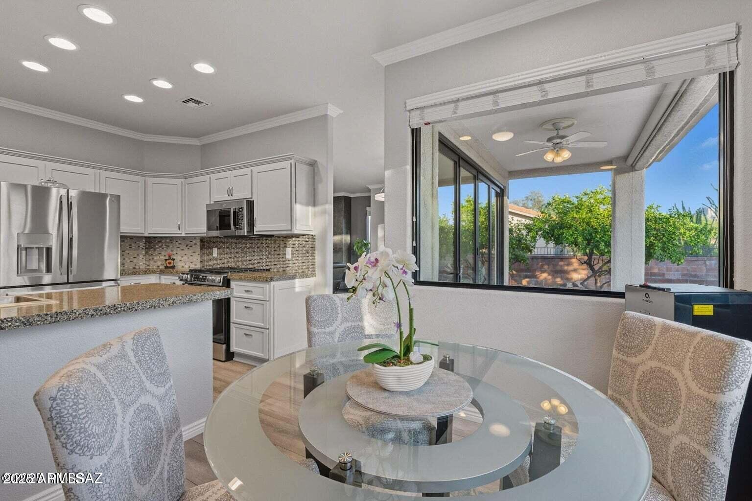14705 North Palm Ridge Drive Oro Valley, AZ 85755 - Photo 14 of 49 a kitchen with stainless steel appliances granite countertop a stove a sink a dining table and chairs