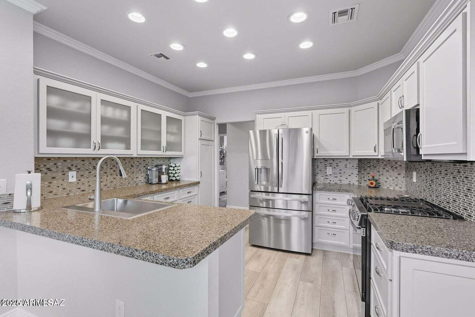 14705 North Palm Ridge Drive Oro Valley, AZ 85755 - Photo 16 of 49 a kitchen with stainless steel appliances granite countertop a sink stove and refrigerator
