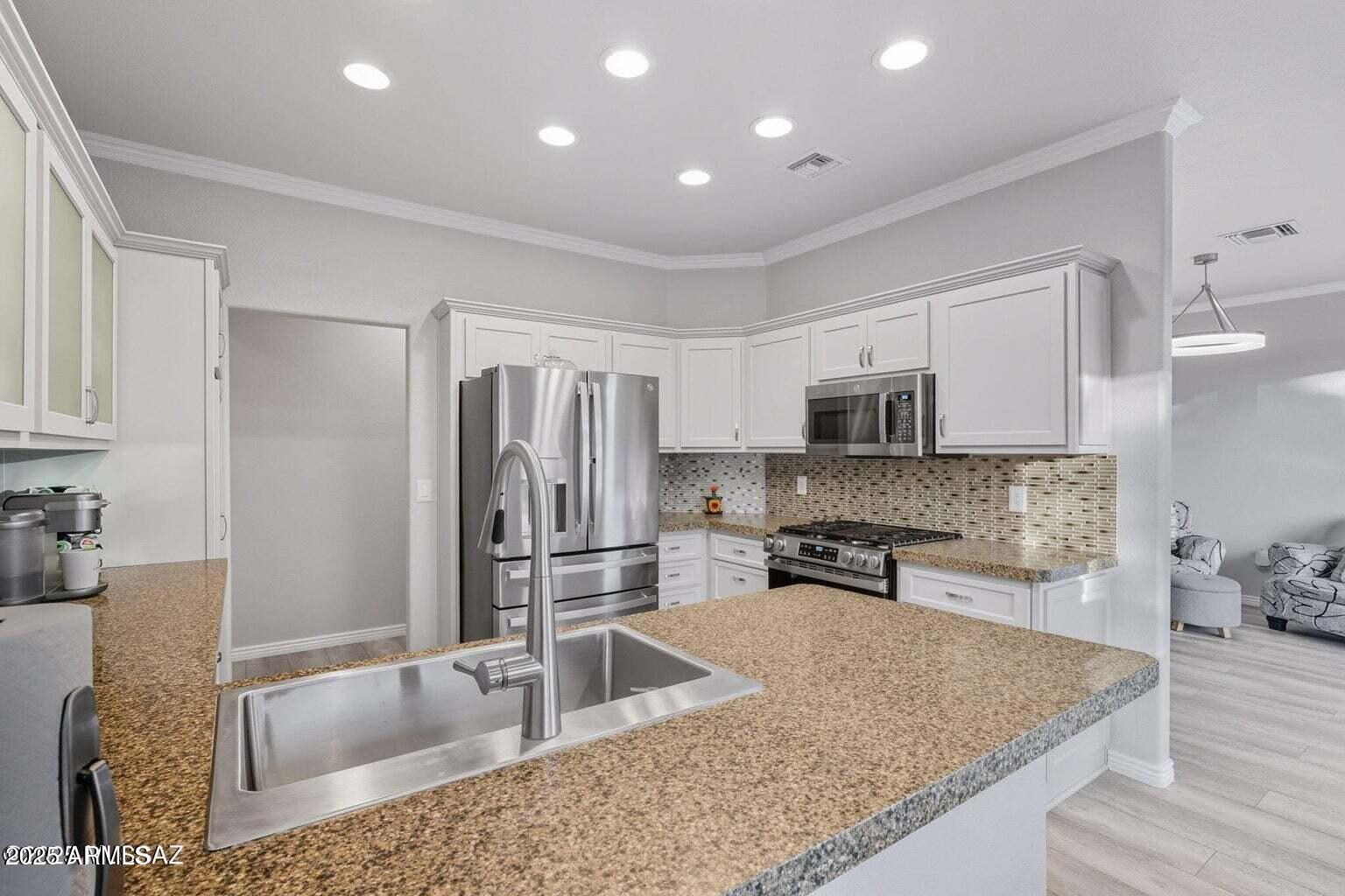14705 North Palm Ridge Drive Oro Valley, AZ 85755 - Photo 18 of 49 a kitchen with stainless steel appliances granite countertop a sink stove and refrigerator