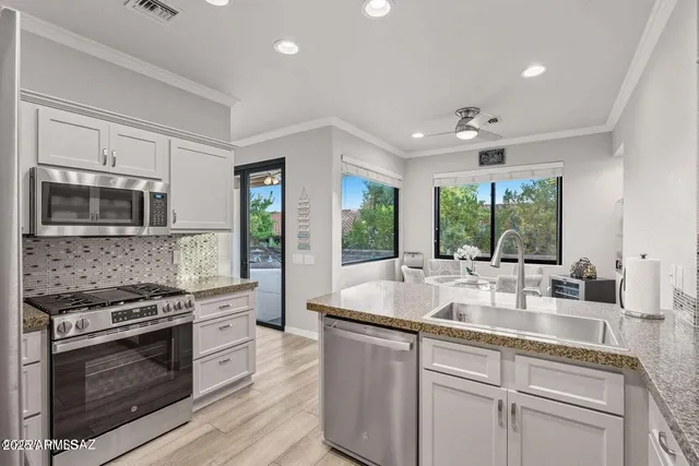 a kitchen with stainless steel appliances granite countertop a sink stove and refrigerator