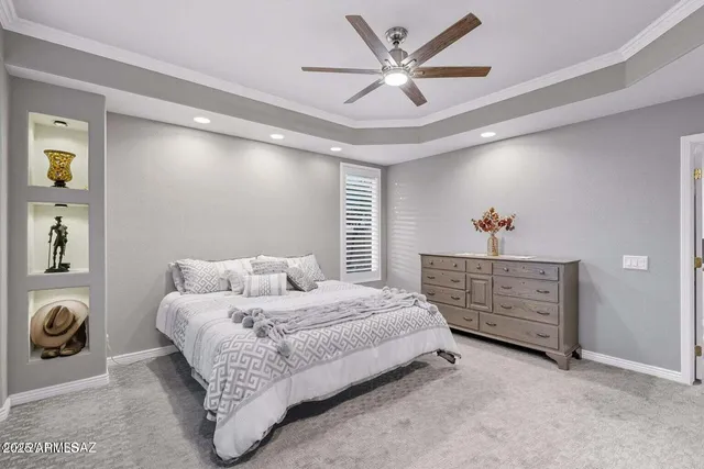 a bedroom with a bed a couch and a ceiling fan