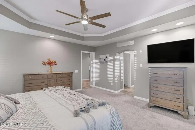 a bedroom with a bed a chandelier and dresser