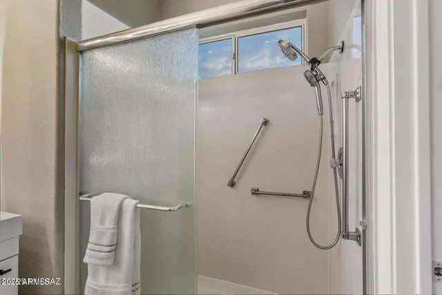 a bathroom with a double vanity sink mirror and shower