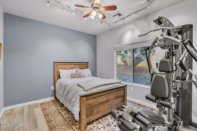 a walk in closet with wooden floor and windows