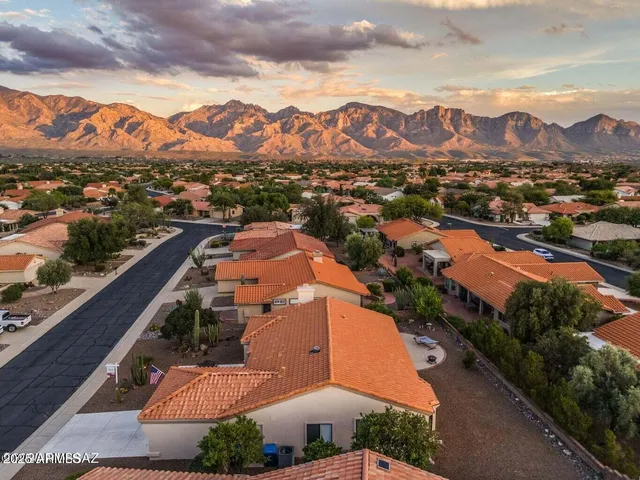 an aerial view of multiple houses with a yard