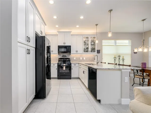 a kitchen with stainless steel appliances kitchen island granite countertop a refrigerator a sink and a stove