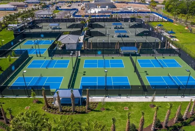 a dining room with wooden floor a chandelier a wooden table and chairs