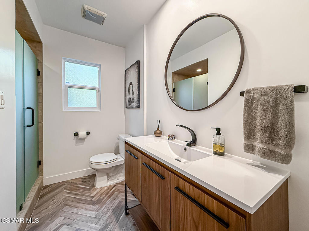 4184 Lanai Road Encino, CA 91436 - Photo 12 of 32 a bathroom with a sink a mirror and a toilet