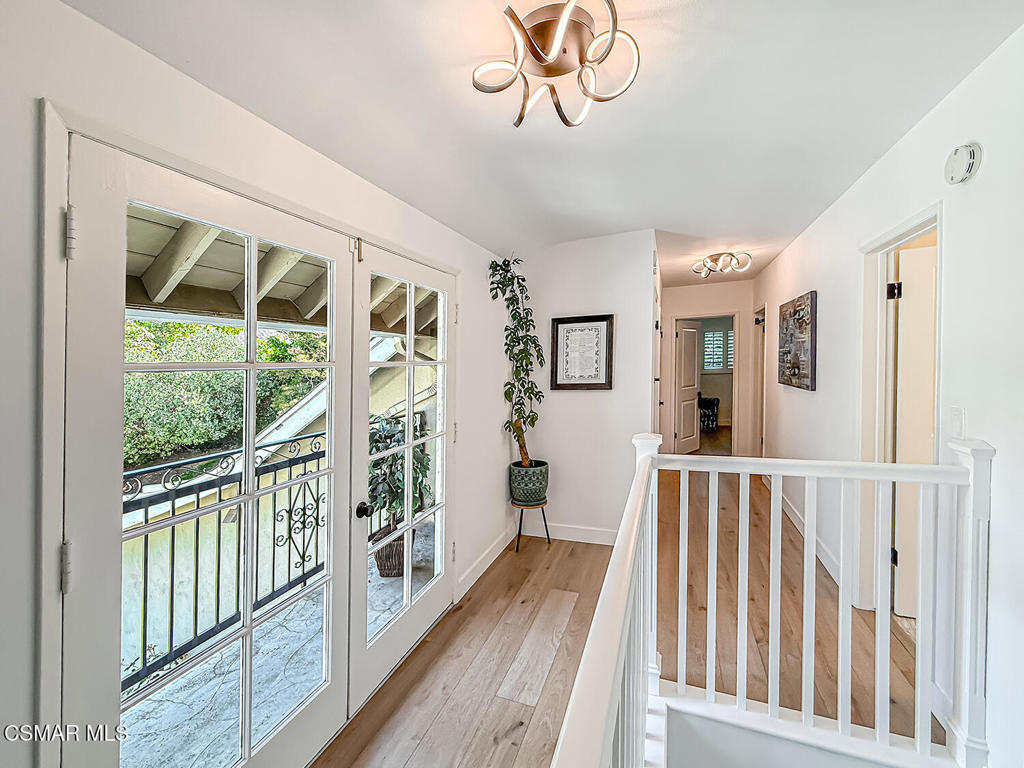 4184 Lanai Road Encino, CA 91436 - Photo 13 of 32 a view of a hallway with wooden floor and windows