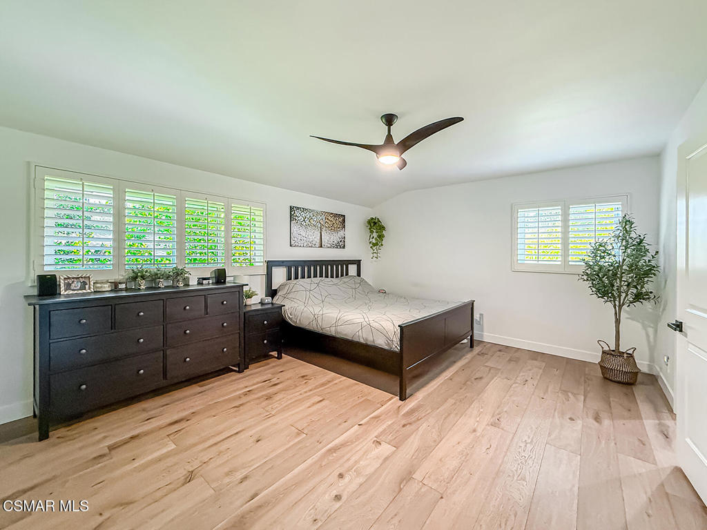 4184 Lanai Road Encino, CA 91436 - Photo 19 of 32 a bedroom with a large bed and a wooden floor