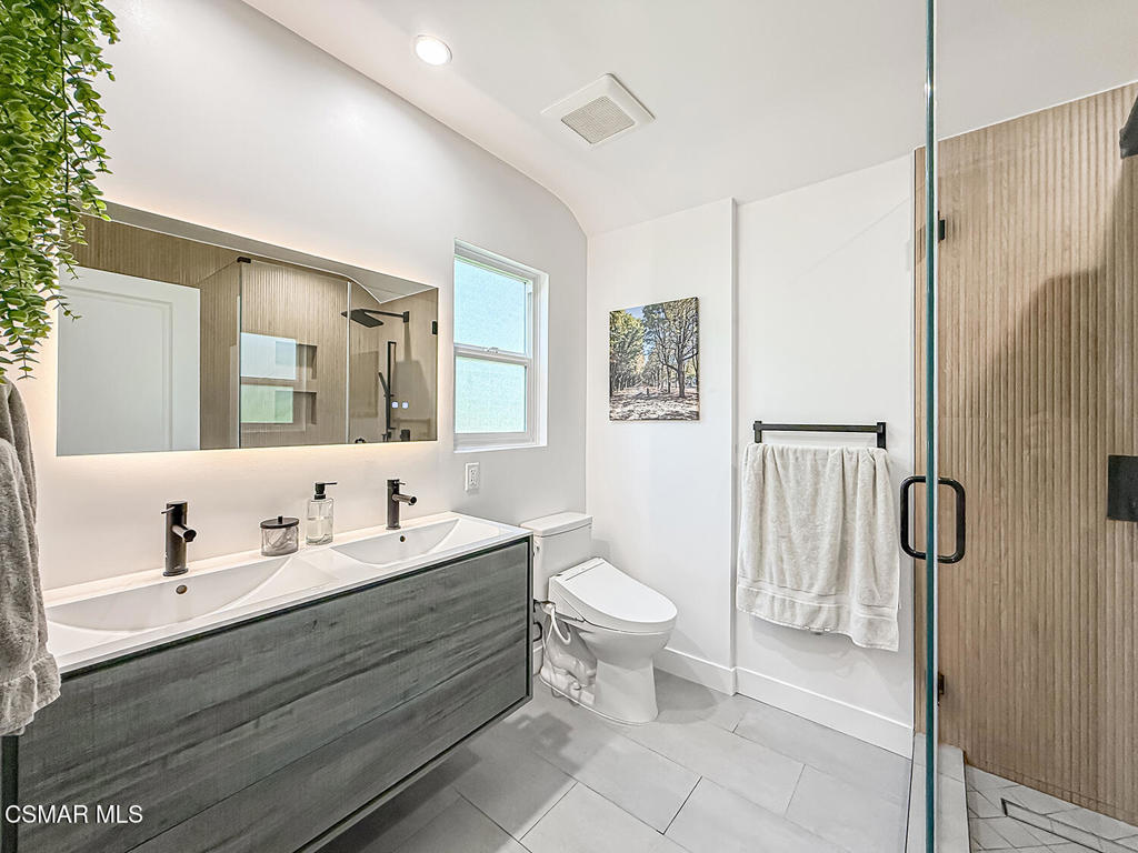 4184 Lanai Road Encino, CA 91436 - Photo 21 of 32 a bathroom with a double vanity sink toilet and shower