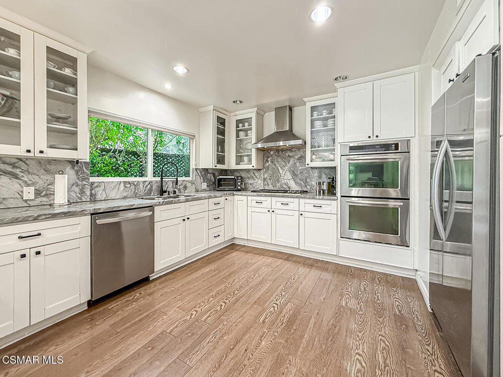 4184 Lanai Road Encino, CA 91436 - Photo 9 of 32 a kitchen with stainless steel appliances a refrigerator sink and cabinets