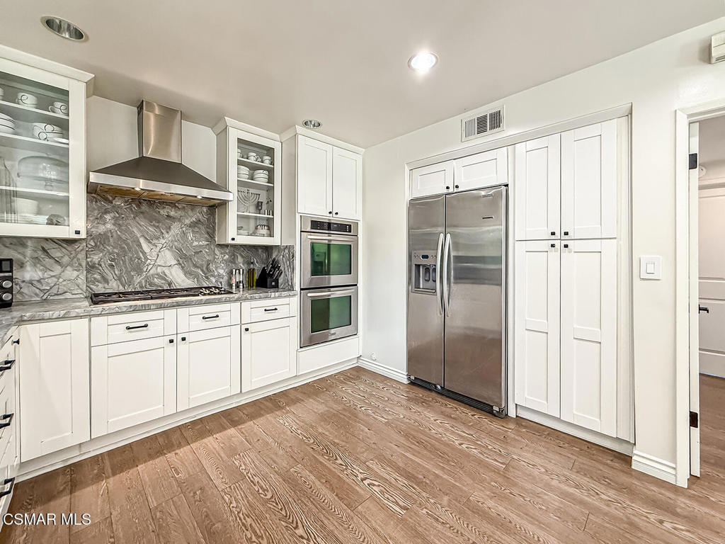 4184 Lanai Road Encino, CA 91436 - Photo 10 of 32 a kitchen with stainless steel appliances granite countertop a refrigerator and a stove top oven