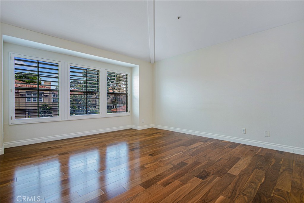 23 Ericson Aisle Irvine, CA 92620 - Photo 14 of 28 a view of an empty room with wooden floor and a window