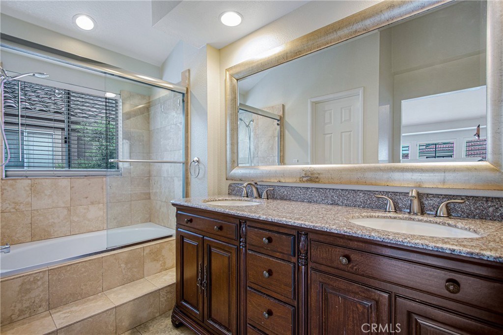 23 Ericson Aisle Irvine, CA 92620 - Photo 16 of 28 a bathroom with a granite countertop bathtub a sink and a large mirror