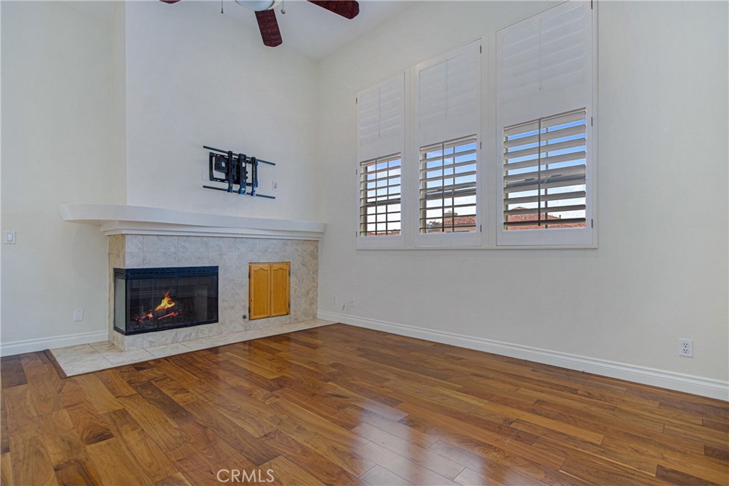 23 Ericson Aisle Irvine, CA 92620 - Photo 5 of 28 a view of an empty room with wooden floor fireplace and a window