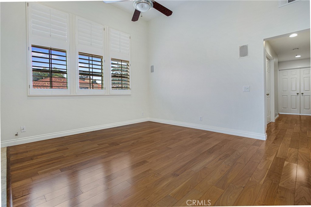23 Ericson Aisle Irvine, CA 92620 - Photo 6 of 28 a view of an empty room with wooden floor and a window