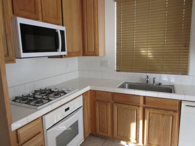 a kitchen with stainless steel appliances a stove microwave and sink