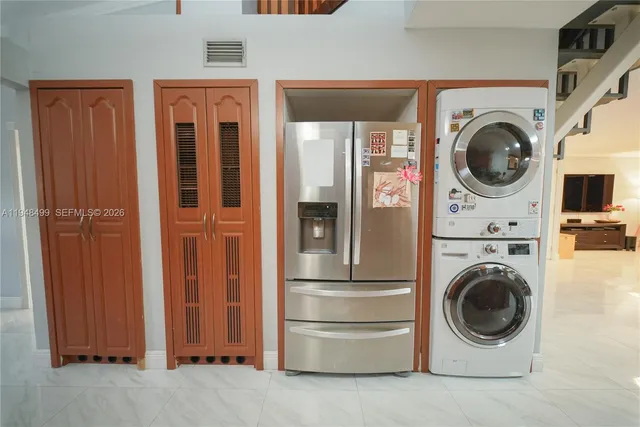 a kitchen with stainless steel appliances granite countertop a stove top oven a sink a dining table and chairs with wooden floor