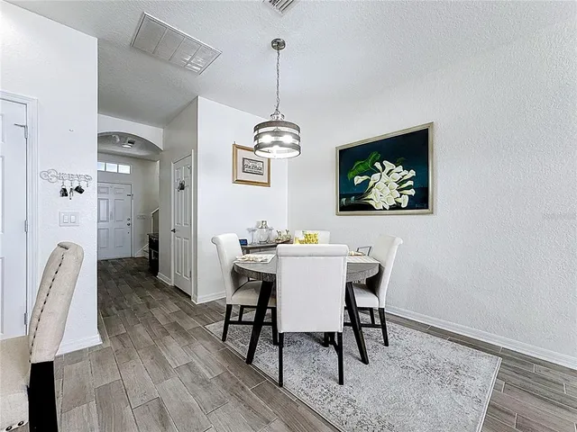 a living room with lots of furniture kitchen view and a dining table