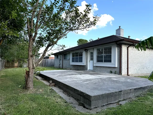 a backyard of a house with table and sofas