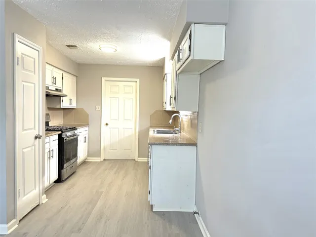 a kitchen with a refrigerator and a stove