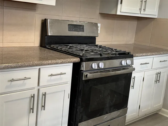 a kitchen with stainless steel appliances granite countertop a stove and a microwave