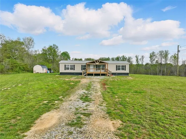 a view of a house with a yard patio and fire pit