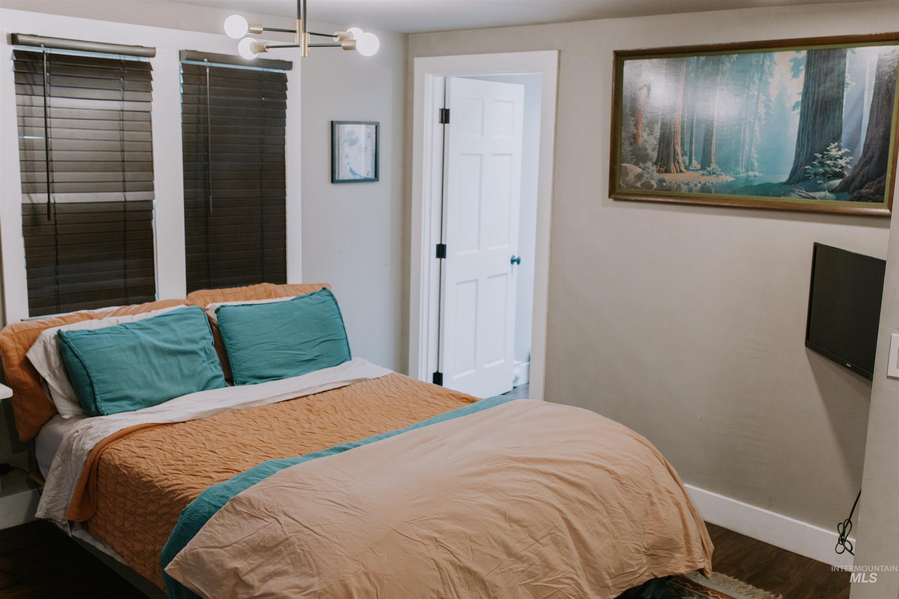 104 North Fairfield Street Council, ID 83612 - Photo 20 of 32 Bedroom featuring a chandelier and dark wood-type flooring
