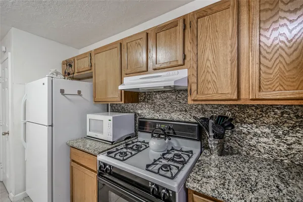 a kitchen with stainless steel appliances granite countertop a stove a refrigerator and a cabinets
