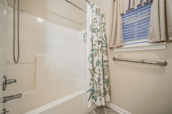 a bathroom with a shower curtain and a window