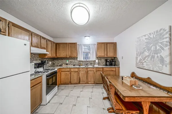 a kitchen with a stove a sink dishwasher and a refrigerator