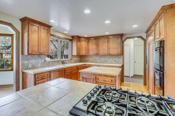 a kitchen with stainless steel appliances granite countertop a stove a sink and a refrigerator