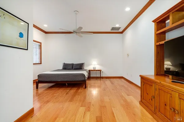 a bedroom with a bed and wooden floor